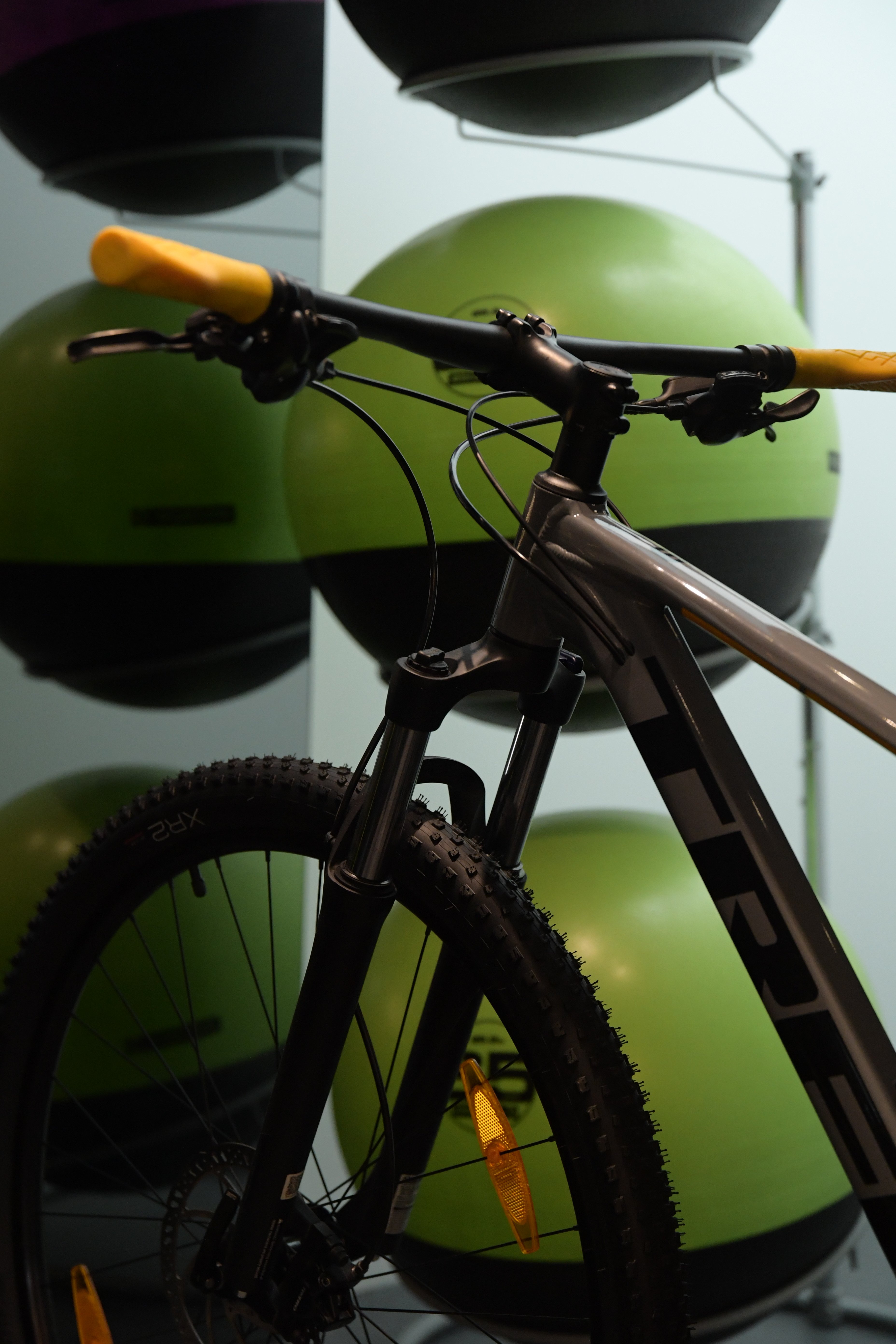 Close-up of bicycle in front of green exercise balls.