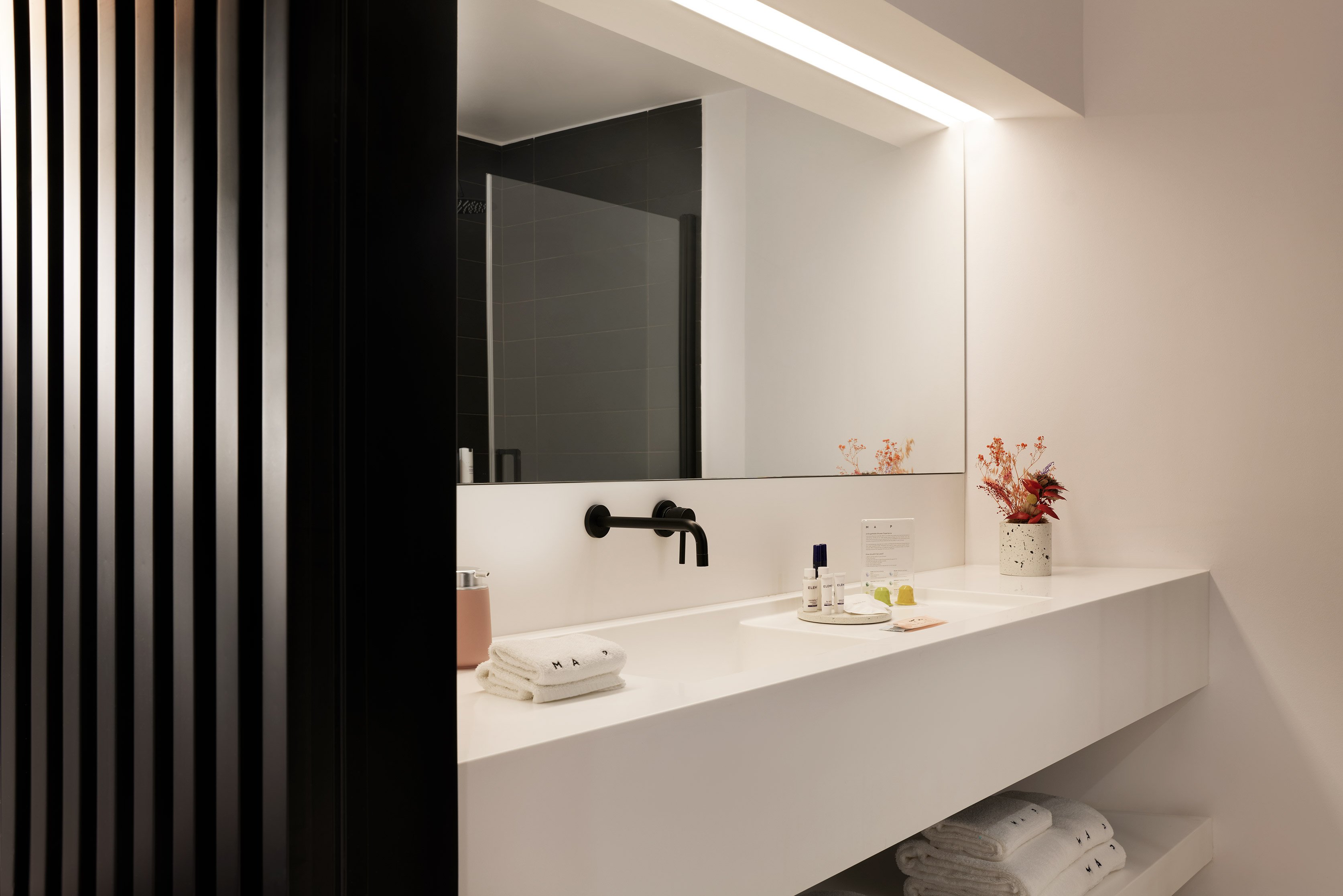 Bathroom with white sink and mirror under soft light.