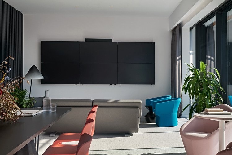 Living area with black wall cabinet, blue and red seating and balcony light.