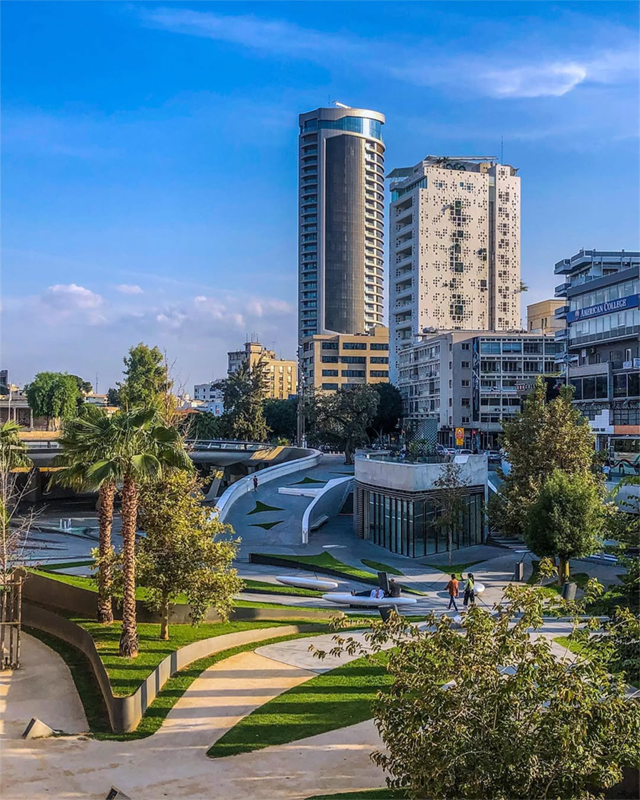 Cityscape with palm trees and tall buildings in sunlight.