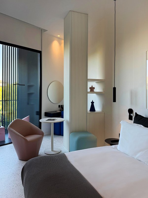 Bedroom with minimalist décor and small seating area.