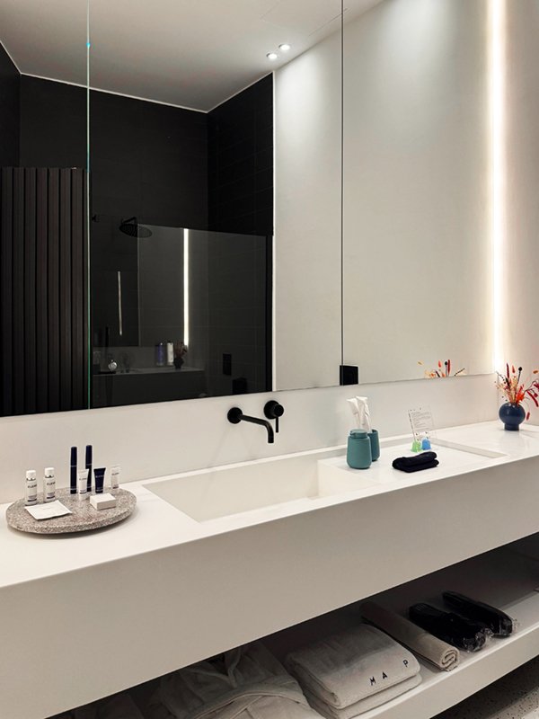 Bathroom with large sink, modern fixtures and mirror lighting.