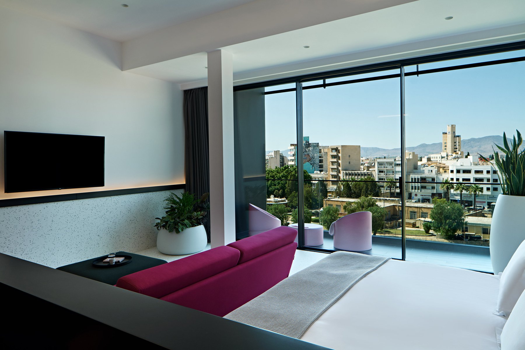 Balcony view framed by tall planters and modern buildings.