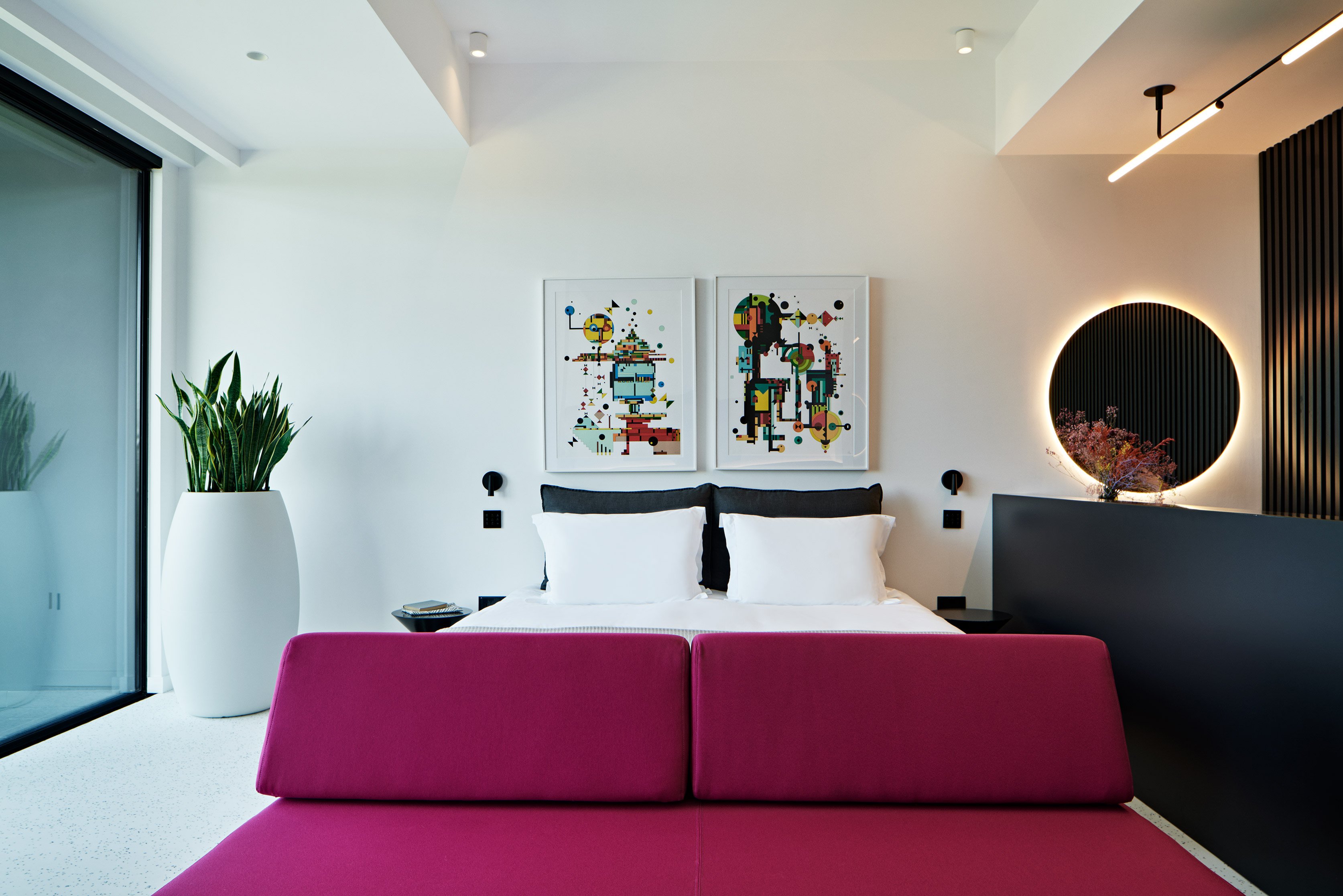 Living area with magenta sofa and art feature on the wall.