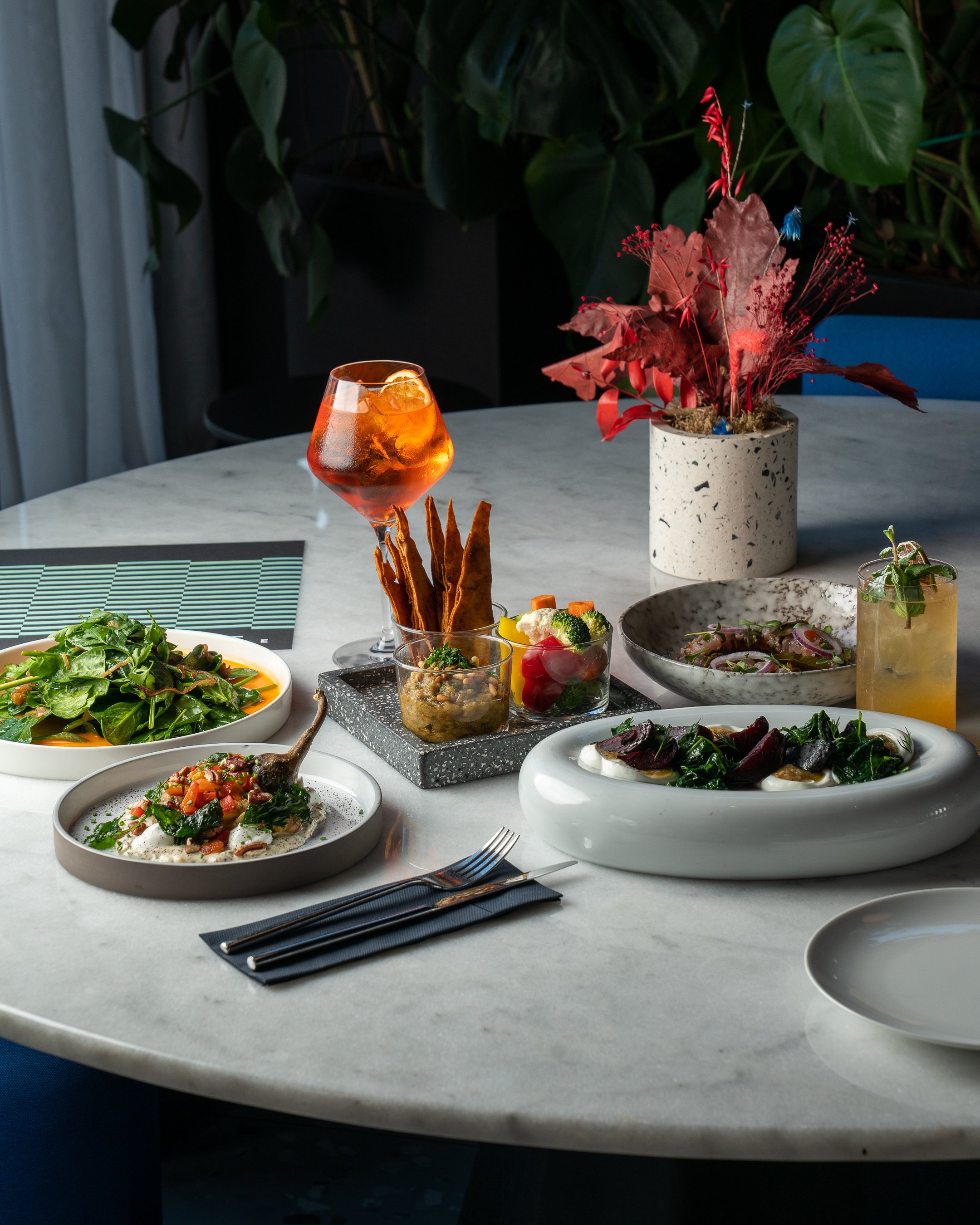 Table with several dishes and drinks arranged for dinner.