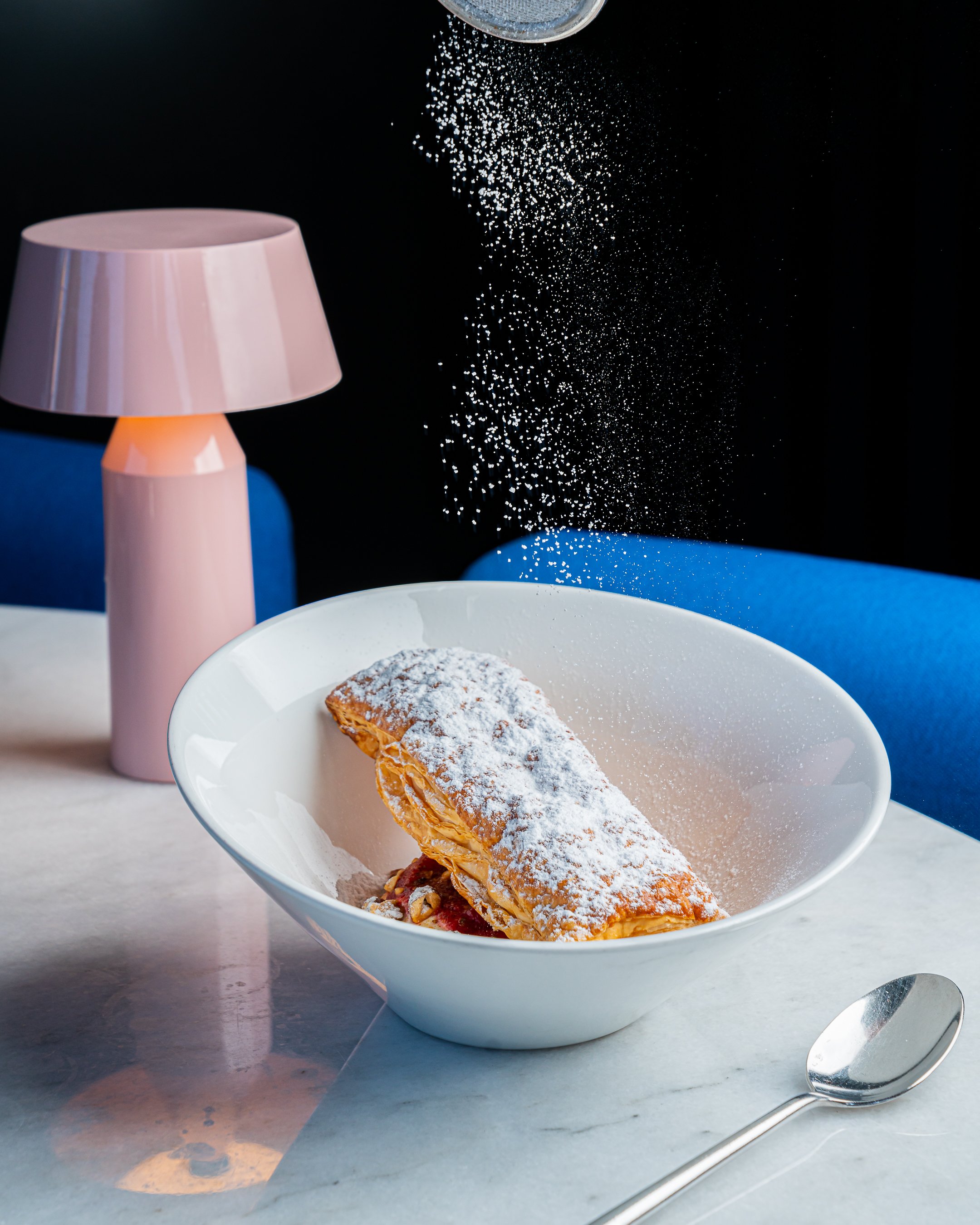 Mille-feuille pastry dusted with powdered sugar under soft light.