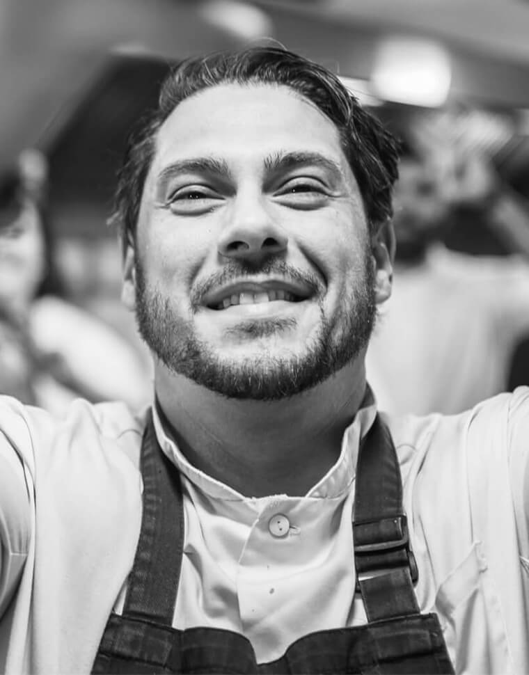 Smiling chef portrait in black and white.