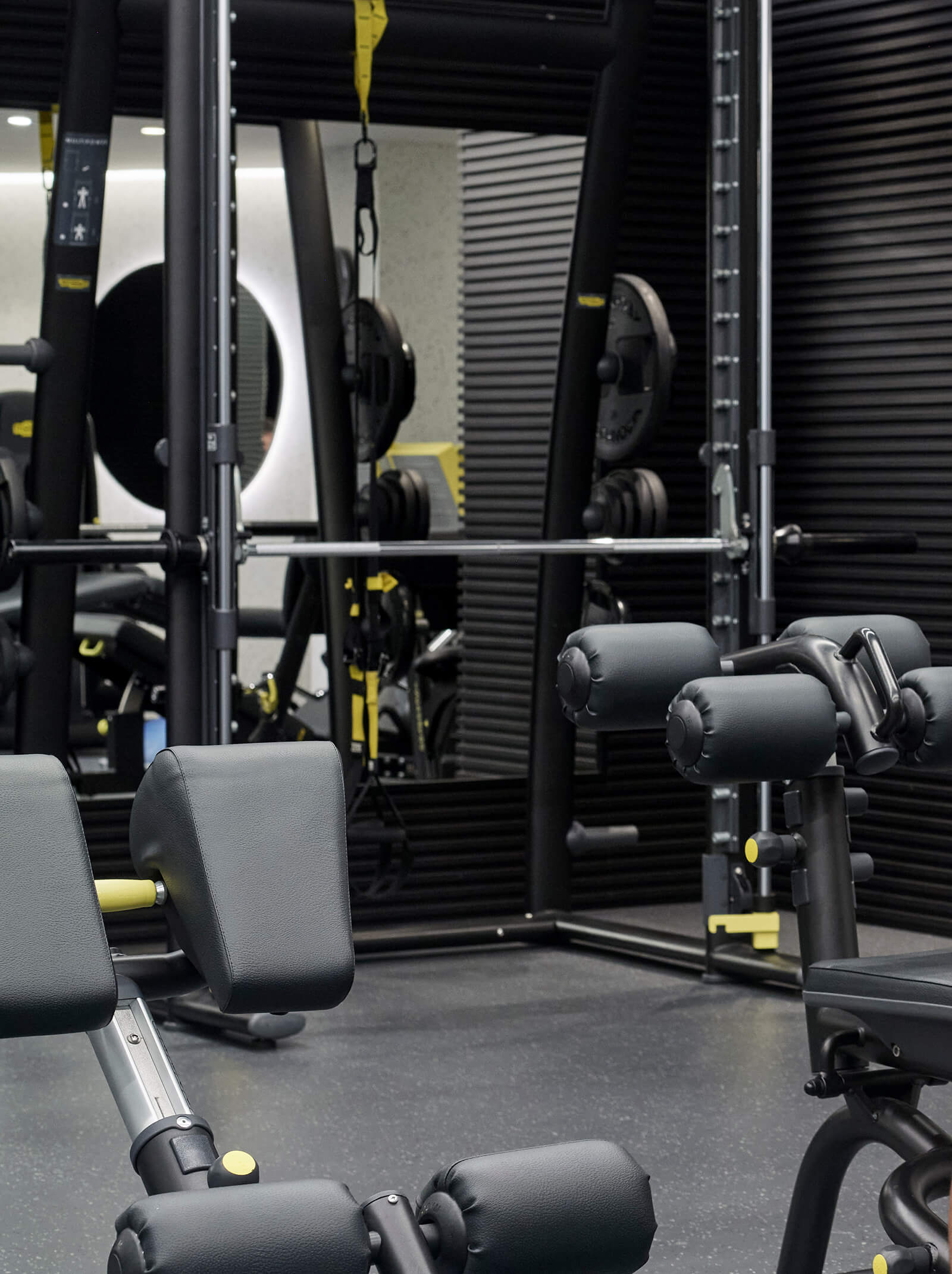 Weightlifting station with fitness equipment and mirrors in the gym.